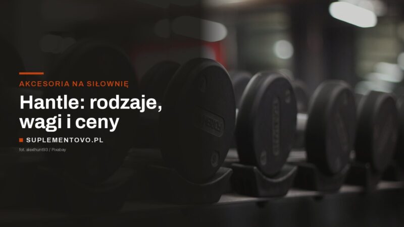 Rząd gumowanych hantli stałych ułożonych na metalowym stojaku w siłowni