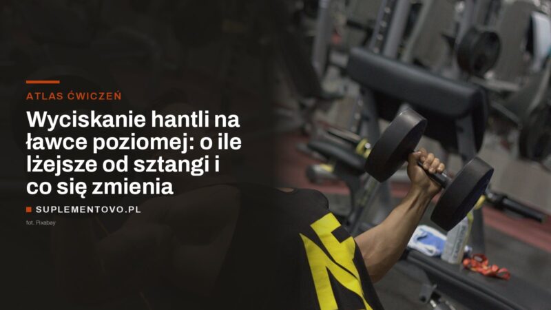 Trenujący wyciska hantel leżąc na ławce na siłowni