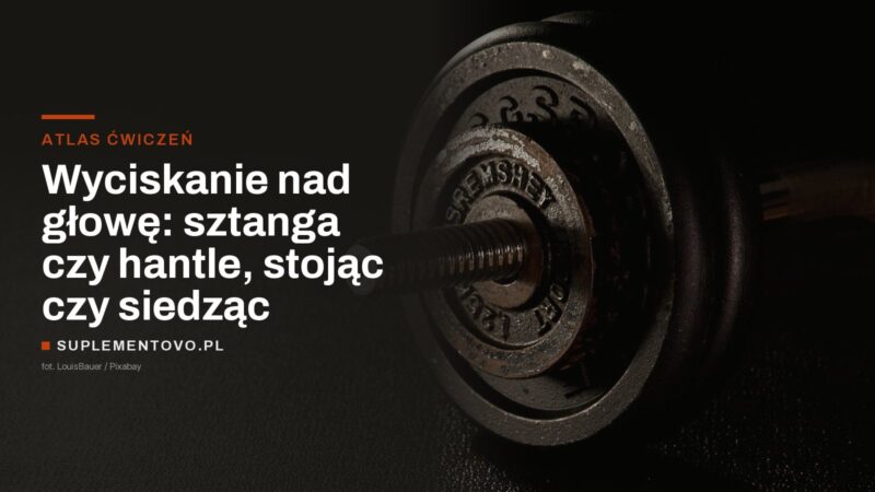 Zbliżenie hantla z żeliwnymi obciążnikami leżącego na macie siłowni