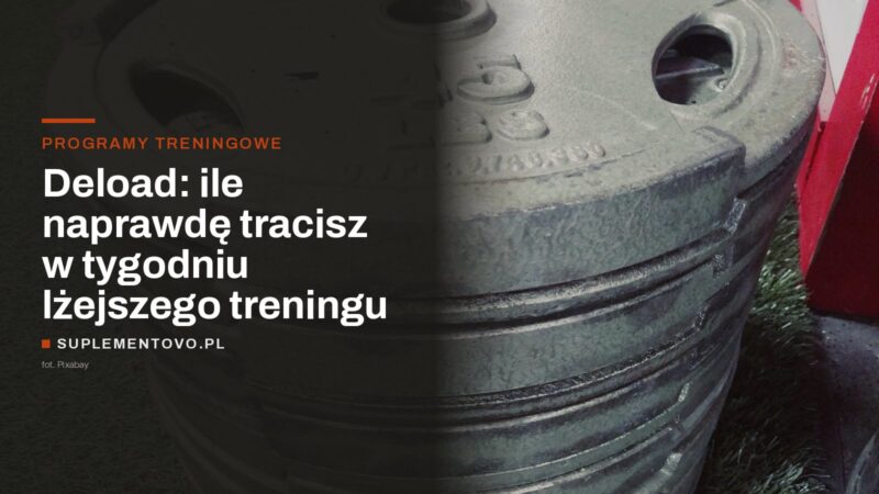 Stos talerzy obciążeniowych odstawionych na podłodze siłowni