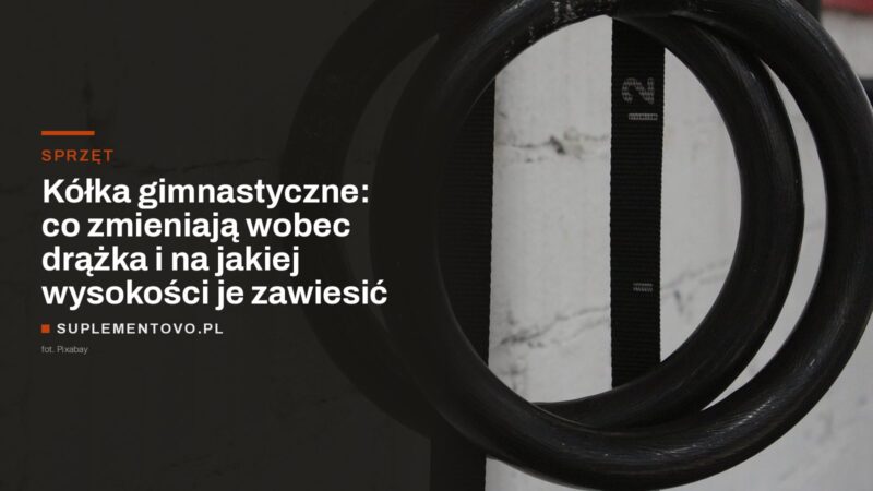Dwa ciemne kółka gimnastyczne zawieszone na czarnych taśmach