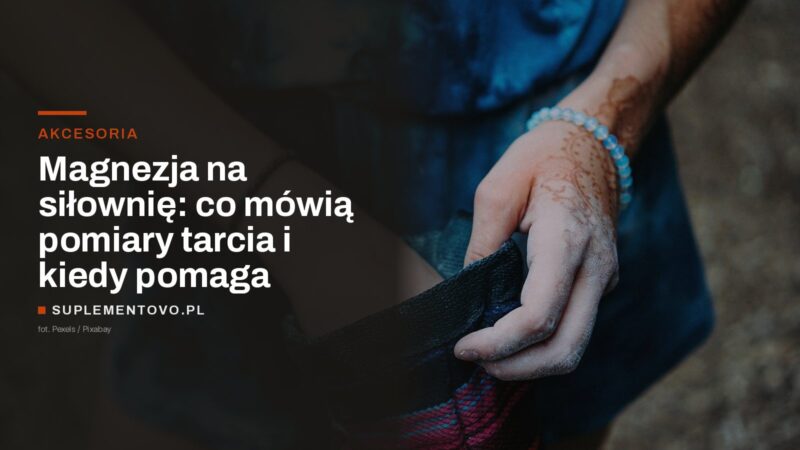 Dłoń pokryta magnezją sięgająca do woreczka z magnezją