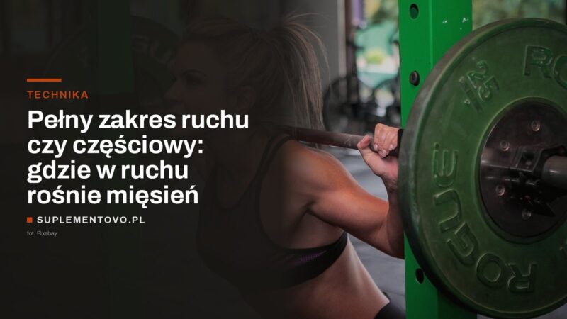 Kobieta w dolnej fazie przysiadu ze sztangą na siłowni