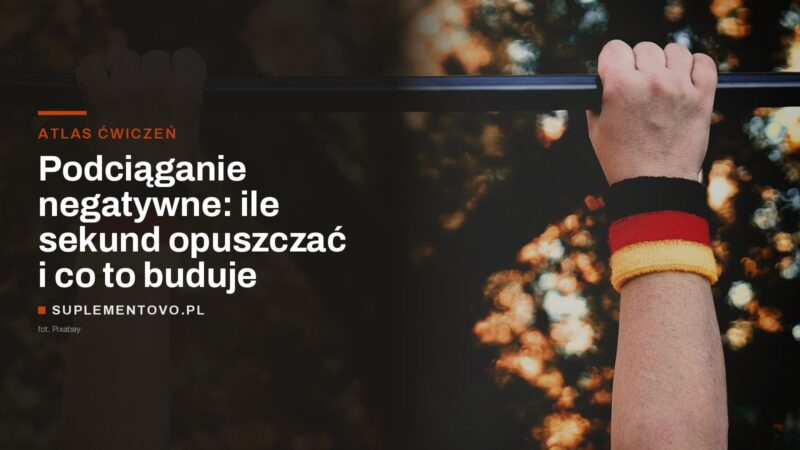 Dłonie trzymające drążek do podciągania, w tle rozmyte światła