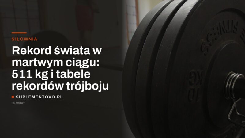 Obciążona sztanga z talerzami na podłodze sali treningowej